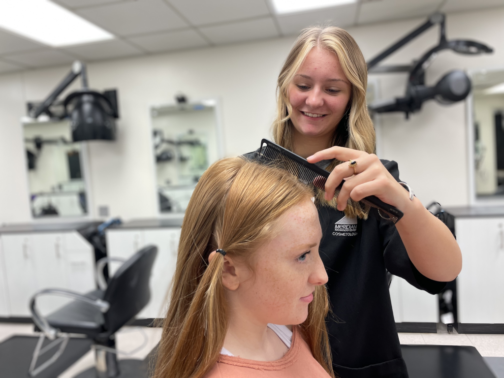 Cosmetology student prepares hair for cut for wigs for kids.