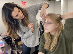 Toni Marlo demonstrates proper makeup application for Abigail Inman.